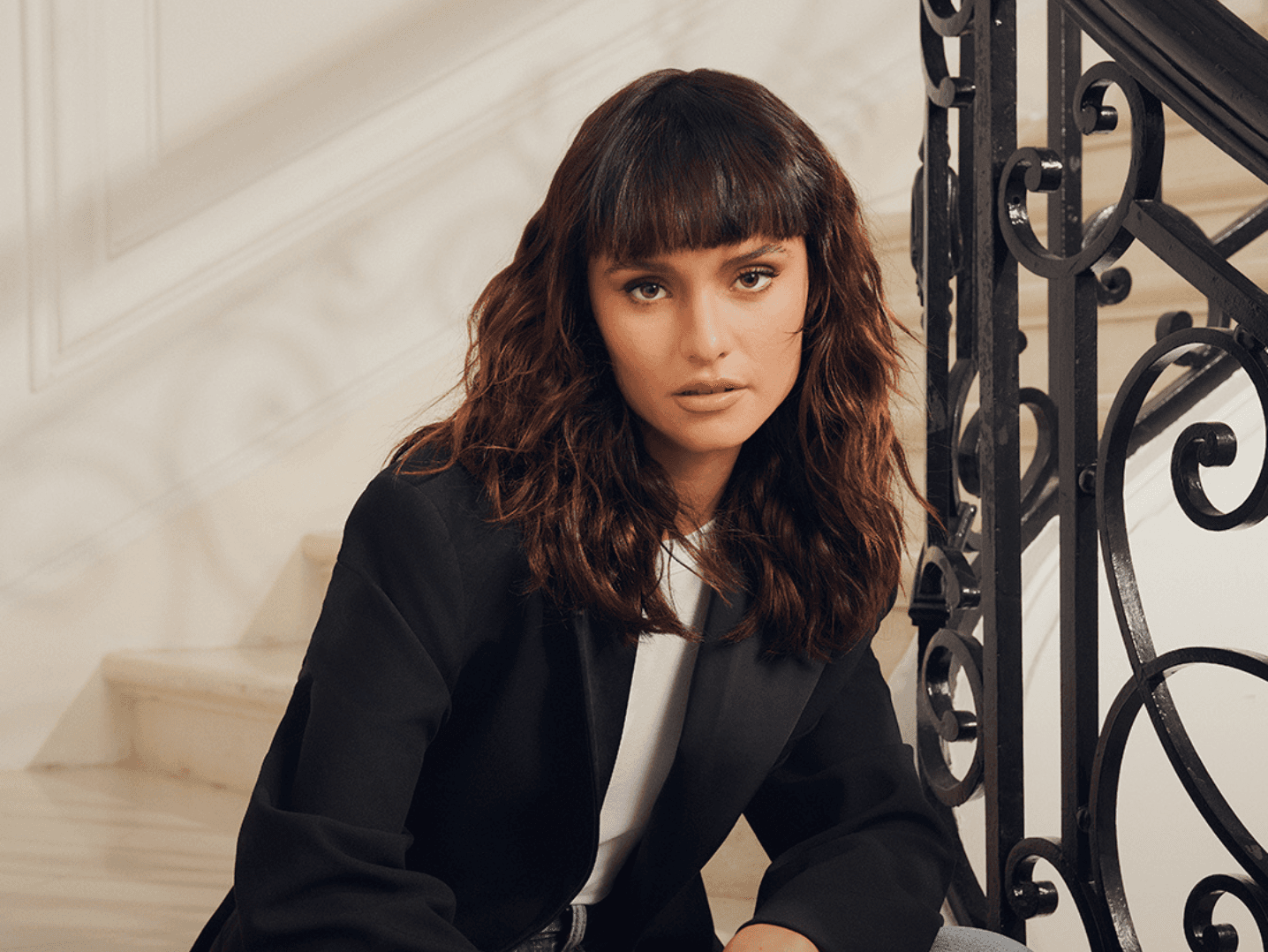 femme avec une coupe brune mi-longue ondulé avec une frange droite structurée
