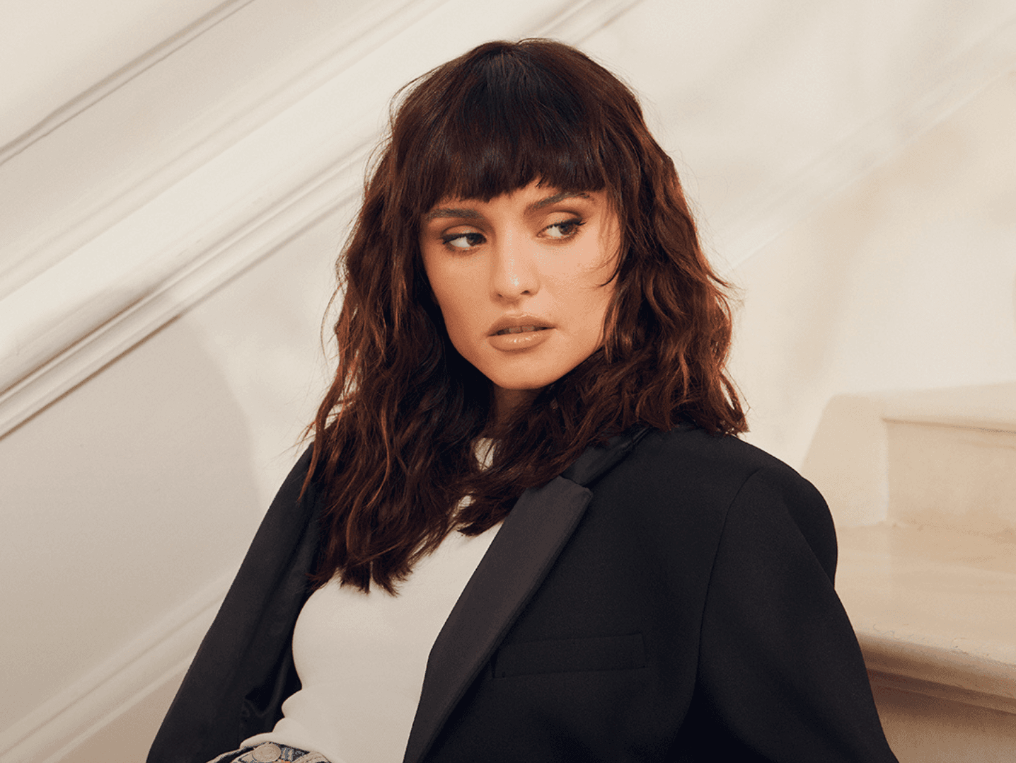 femme avec une coupe brune mi-longue ondulé avec une frange droite structurée
