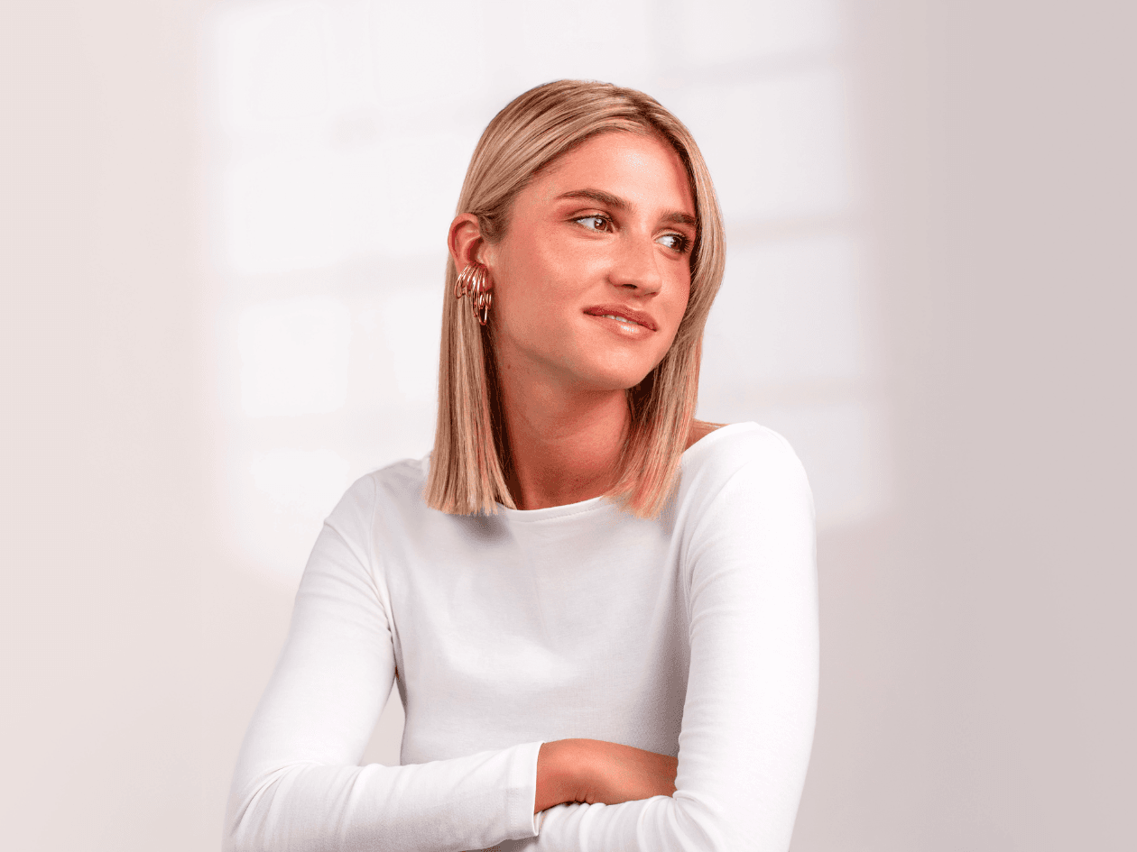 Portrait d'une femme aux cheveux blonds mi-longs, parfaitement lisses et lumineux, mettant en avant un résultat d'un soin botox capillaire.